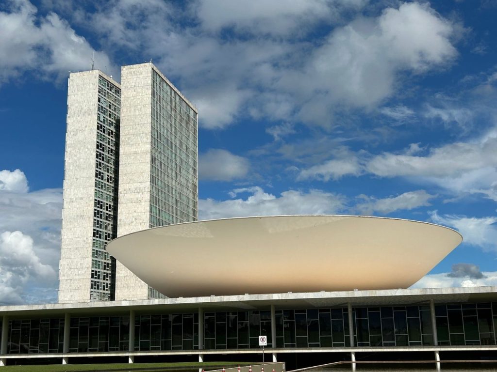 Mulheres avançam no Congresso em 2026, mas distância para o eleitorado permanece Vista externa do Congresso Nacional do Brasil, em Brasília, com suas cúpulas e torres sob céu claro.