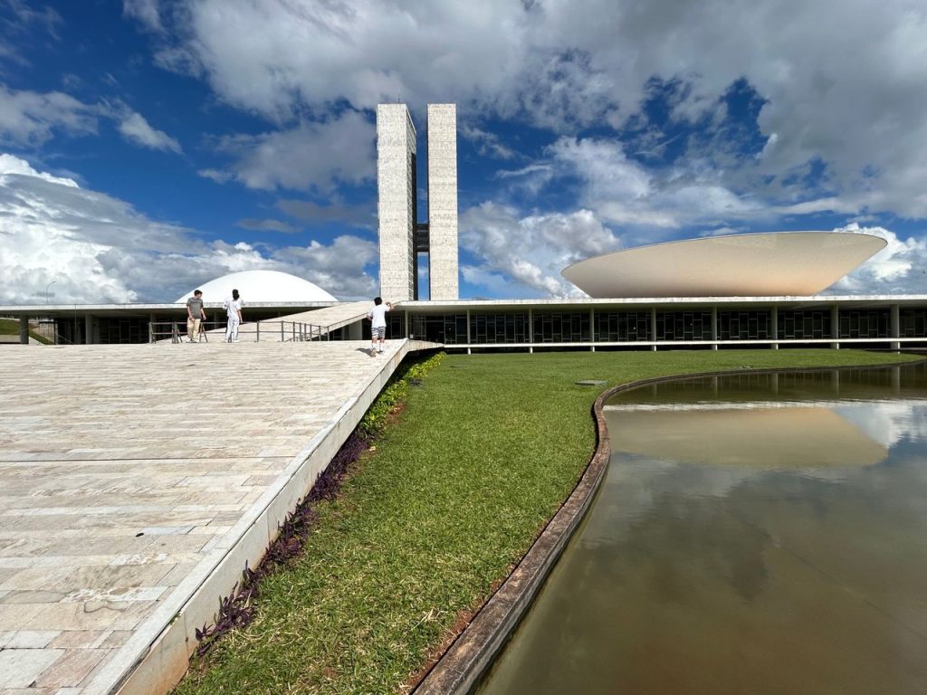 Vista externa do Congresso Nacional brasileiro sob céu claro.