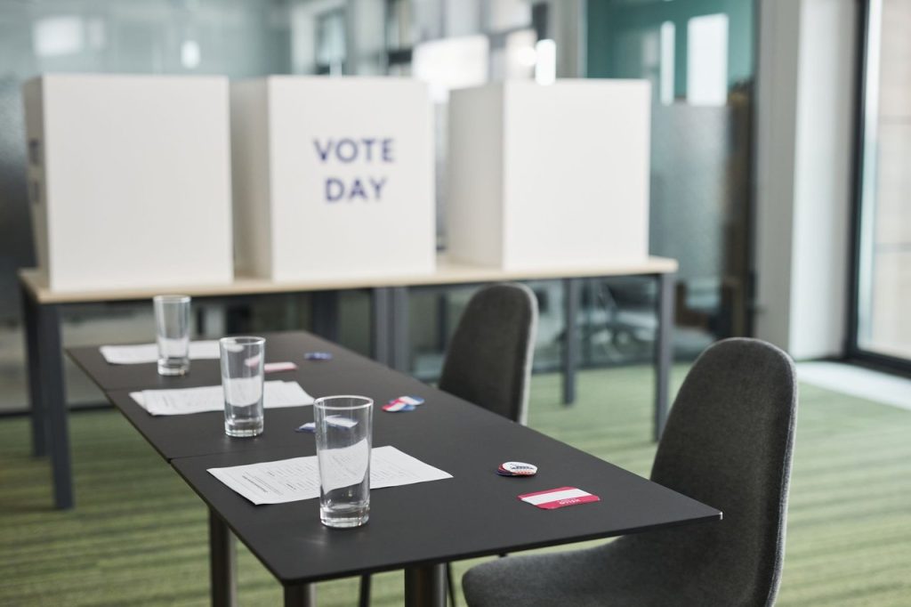 Sete municípios voltam às urnas e escolhem prefeitos em eleições suplementares Seção eleitoral preparada, com mesas, cadeiras e cabines de votação em uma sala.