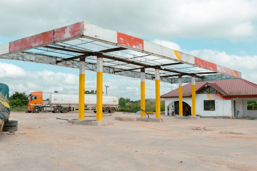 Posto de combustíveis vazio com caminhão-tanque estacionado em uma área aberta sob céu nublado